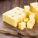 swiss cheese on a wooden chopping board
